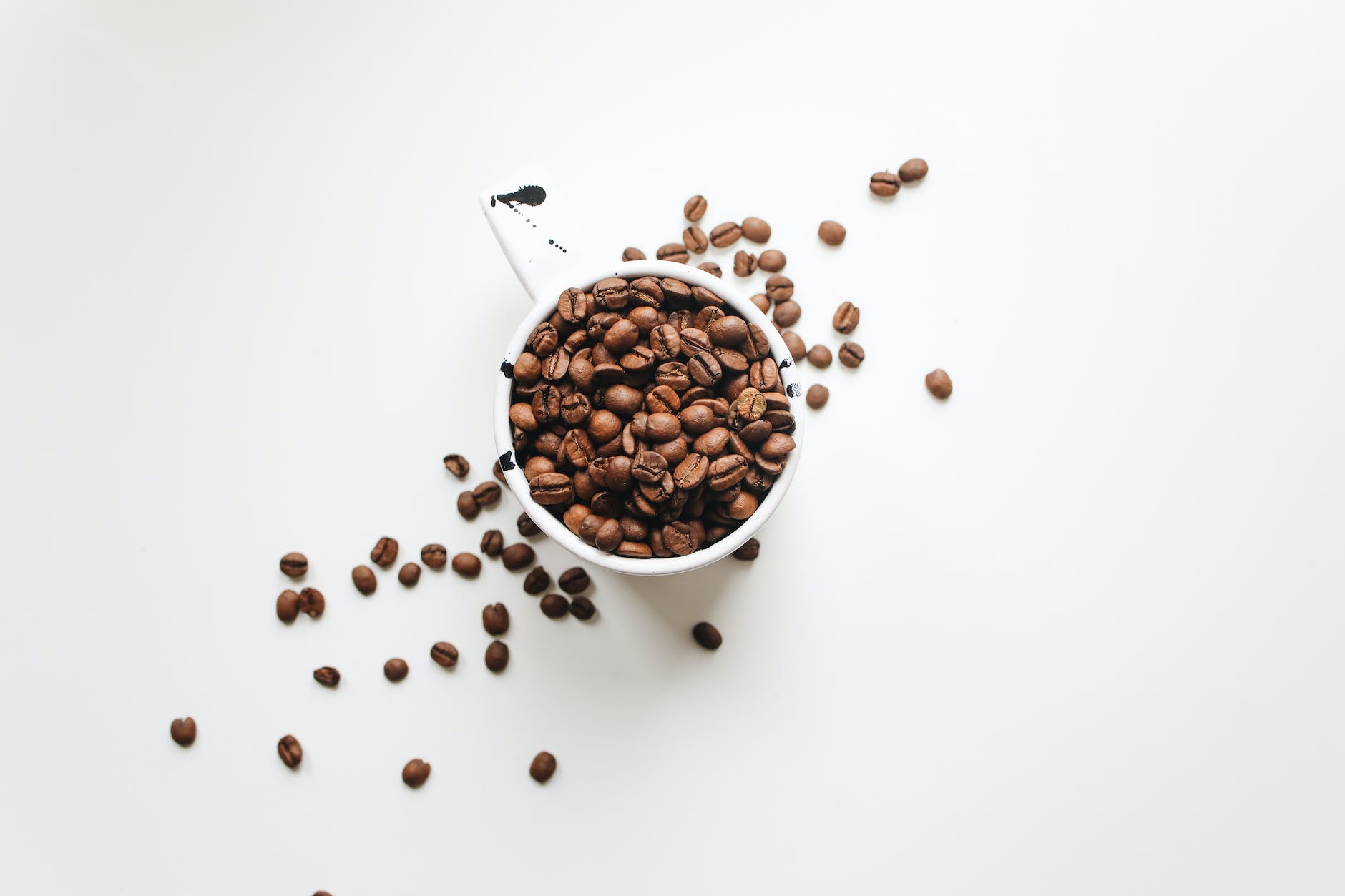 white ceramic mug full of coffee beans