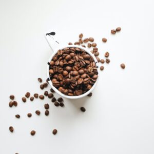 white ceramic mug full of coffee beans